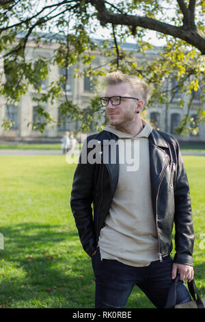 Smart smiling guy in casual clothes looking to the right Stock Photo