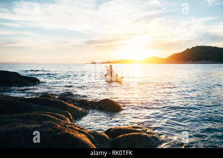 Man paddling the kayak at sunset. Canoeing, kayaking, paddling Stock Photo