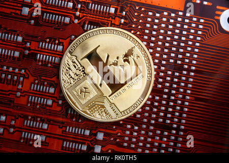 Litecoin gold coin on a orange or red & black computer flexible circuit. Stock Photo