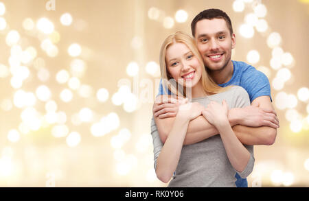 smiling couple hugging over festive lights Stock Photo