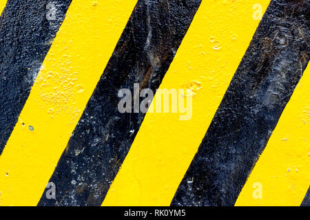 Old brick wall with black and yellow diagonal stripes. Rio de Janeiro, Brazil. 2019 Stock Photo