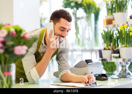 florist man calling on smartphone at flower shop Stock Photo