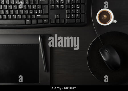 Total black desk with pc, tablet and cup of coffee Stock Photo