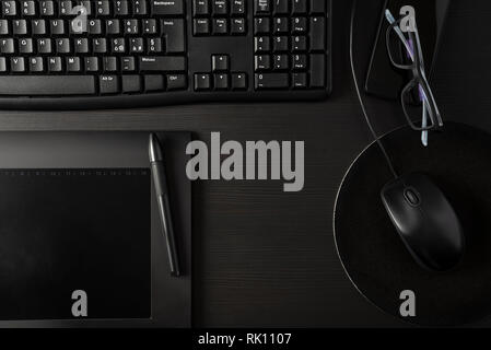 Total black desk with pc, tablet and personal items Stock Photo