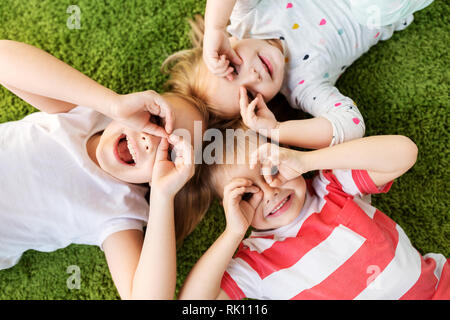 happy little kids looking through finger glasses Stock Photo