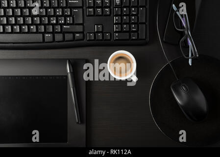 Total black desk with pc, tablet, personal items and cup of coffee Stock Photo