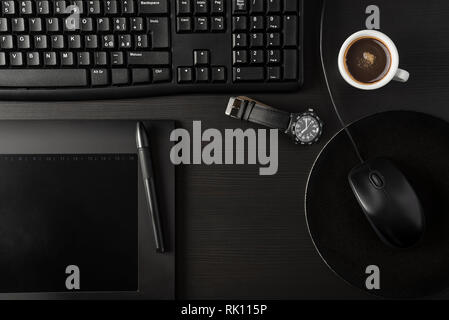 Total black desk with pc, tablet and cup of coffee Stock Photo
