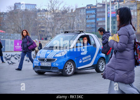 Municipal Tourist Team agent in a car assisting a tourist with information a Taksim Square on a grey day.  Istanbul, Turkey - December 2018 Stock Photo