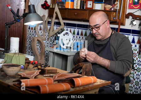 craftsman working the leather in his small workshop Stock Photo
