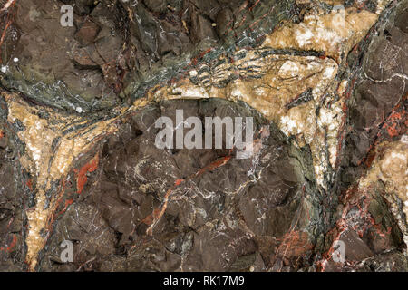 A close-up area of rock with colored layers and veins. Stock Photo