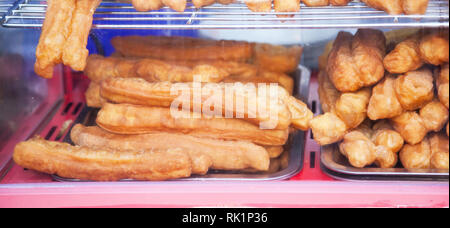 Youtiao (Chinese fried churro, Chinese cruller, Chinese oil stick, Chinese doughnut, fried breadstick), long golden brown deep fried dough strip, eate Stock Photo