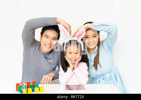 Young lovely Asian family, parents and small kid girl doing funny pose and smiling together at home. Happy family love concept Stock Photo