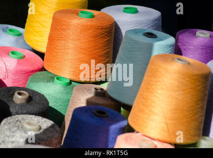 Colorful thread spools, one above the other. Coils with colurful threads. Stock Photo