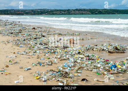 Pollution of plastic bottles, cups, straws and other litter washing up on the beach at Jimbaran Bay, Bali Indonesia. Stock Photo