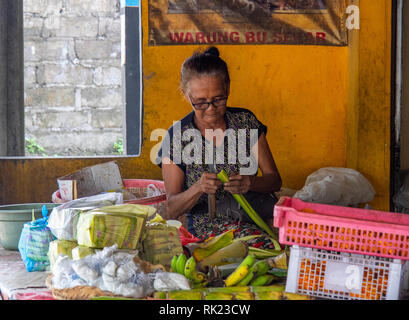 Elderly lady preparing food in a restaurant or traditional warung, Jimbaran, Bali Indonesia. Stock Photo