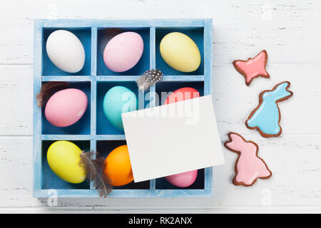 Easter eggs and gingerbread cookies on wooden table. Rabbits, butterflies and eggs. Greeting card. Top view with space for your greetings Stock Photo