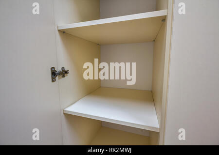 Interior of white plastic cabinet or clothing wardrobe with many empty shelves with open doors. Furniture design and installation. Stock Photo