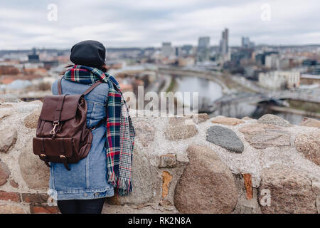 Stylish girl in jeans jacket walk at the Vilnius background on top of Gediminas Castle, Lithuania Stock Photo