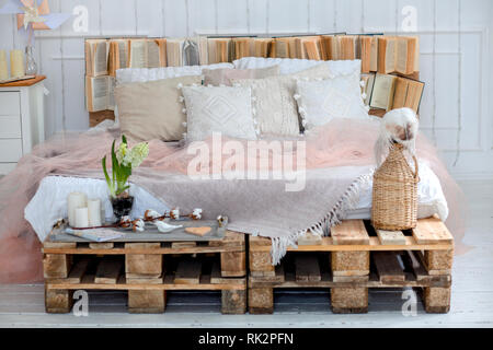 modern interior and home decor concept. with pillows and a blanket, candles. a big star of the lamps. deer on the pillows. wooden. Stock Photo