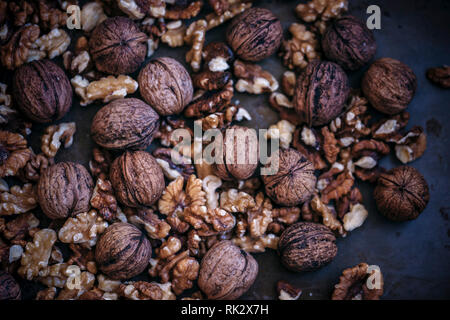 Mix of walnuts in shell and without shell on a black background Stock Photo