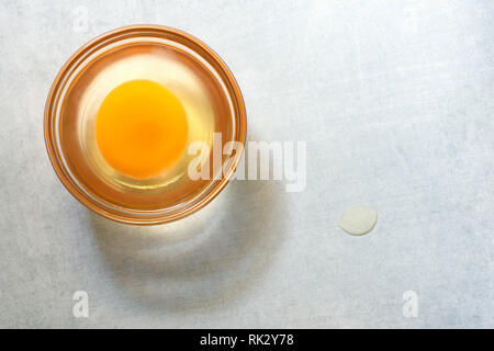 A raw egg in a small glass dish. Stock Photo