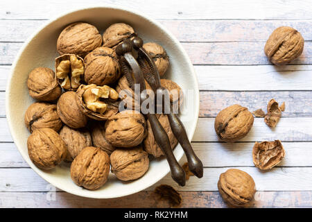 Cracked and whole walnuts in a bowl. Stock Photo