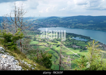 Mondsee lake in Austria with green fields and clouds, as seen from above on a bright, Summer day. Top holiday location near Salzburg. Stock Photo