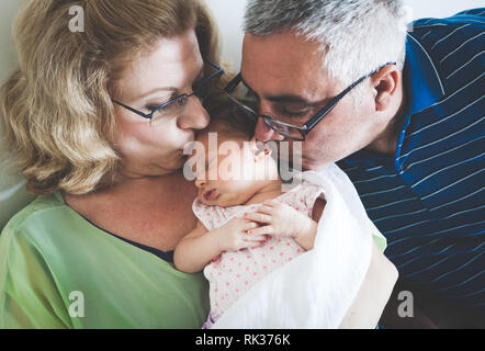 Grandparents Holding Sleeping Newborn Baby Granddaughter. Stock Photo