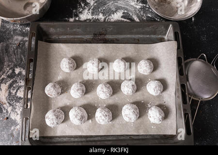 Preparation for the future of chocolate cookies with cracks lies on the baking sheet and waits until it is sent to the oven for baking. The process of Stock Photo