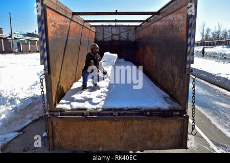 Qazigund, Kashmire, India. 09th February, 2019.Qazigund, J&K, India - A driver seen clearing snow from his truck on a closed National Highway in Qazigund, about 85kms from Srinagar, Indian administered Kashmir. The main National Highway that connects the valley with the rest of country remained closed on Saturday for the fourth consecutive day following an avalanche killing seven people including the three policemen, the two firefighters and the two prisoners. Credit: Saqib Majeed/SOPA Images/ZUMA Wire/Alamy Live News Stock Photo
