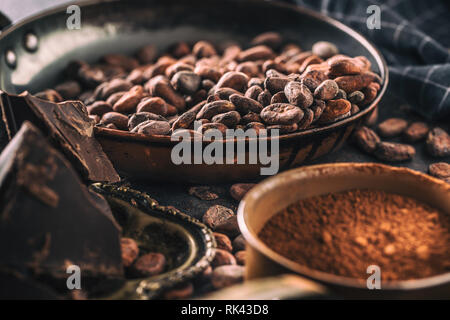 Dark chokolate cocoa beans and powder on concrete table Stock Photo