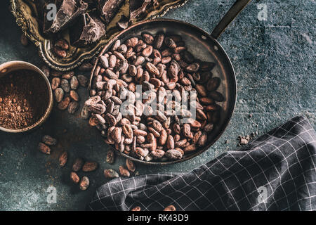 Dark chokolate cocoa beans and powder on concrete table Stock Photo