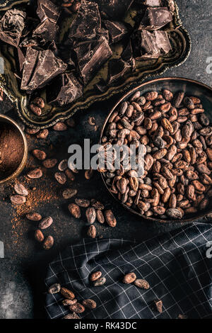 Dark chokolate cocoa beans and powder on concrete table Stock Photo