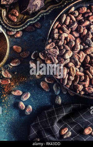 Dark chokolate cocoa beans and powder on concrete table Stock Photo