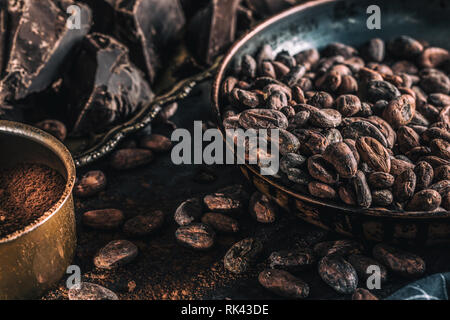 Dark chokolate cocoa beans and powder on concrete table Stock Photo