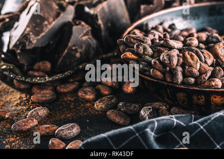 Dark chokolate cocoa beans and powder on concrete table Stock Photo