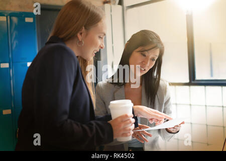 Two female coworkers discussing presentation ideas in modern office Stock Photo