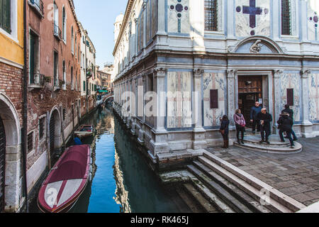 VENICE, ITALY - FEBRUARY 10 2018: Small canal next to a beautiful church Stock Photo