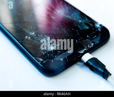 Cell phone with the screen broken by a hammer. non-warranty repairs concept. Stock Photo