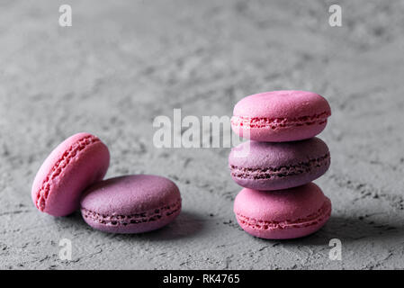 beautiful colorful delicious desserts makarons, stack on gray stone background. Stock Photo
