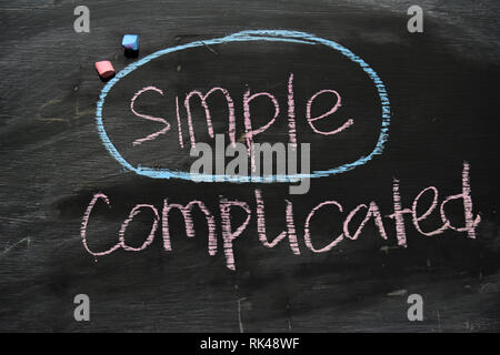 Simple or Complicated written with color chalk concept on the blackboard Stock Photo