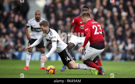 Fulham's Andre Schurrle (left) and Manchester United's Luke Shaw battle for the ball during the Premier League match at Craven Cottage, London. Stock Photo