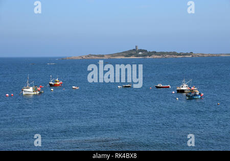 Small Boats Moored in L'eree Bay with Lihou Island and the German Capped Martello Tower of Fort Saumarez Guernsey, Channel Islands.UK. Stock Photo