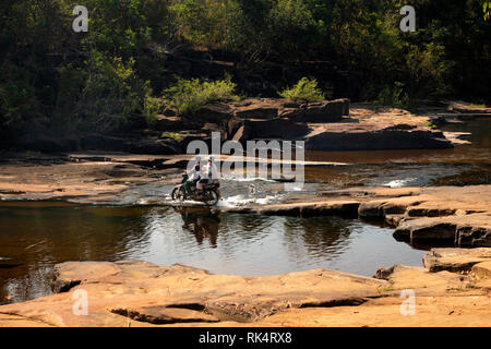 Cambodia, Koh Kong Province, Chi Phat, Chhay Chrei, family of 3 people on motorcycle crossing Bodhi Tree Rapids on Piphot River in dry season Stock Photo