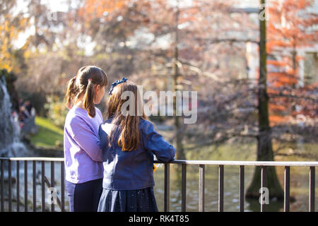 Two girlfriends having fun in a public park in the fall. Stock Photo
