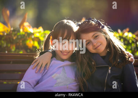Two girlfriends having fun in a public park in the fall. Stock Photo