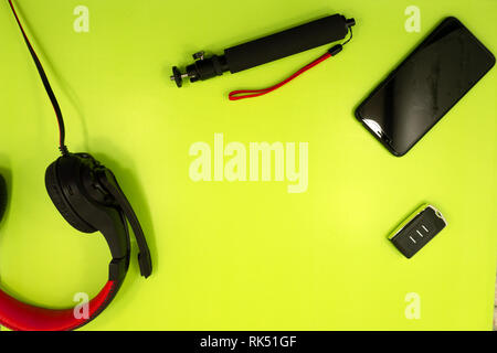 A white smartphone charging with a yellow powerbank on pastel orange and purple background.Charging smartphone on contrast color background.The concep Stock Photo
