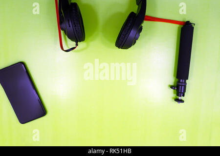 A white smartphone charging with a yellow powerbank set on light blue and yellow background. Charging smartphone on contrast color background. The con Stock Photo