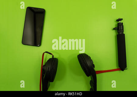 A white smartphone charging with a yellow powerbank on pastel pink and blue background. Charging smartphone on contrast color background. The concept  Stock Photo