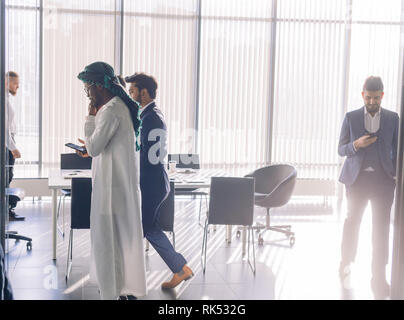 Multicultural business male team workers chatting at meeting, socializing during break at business meeting or conference Stock Photo